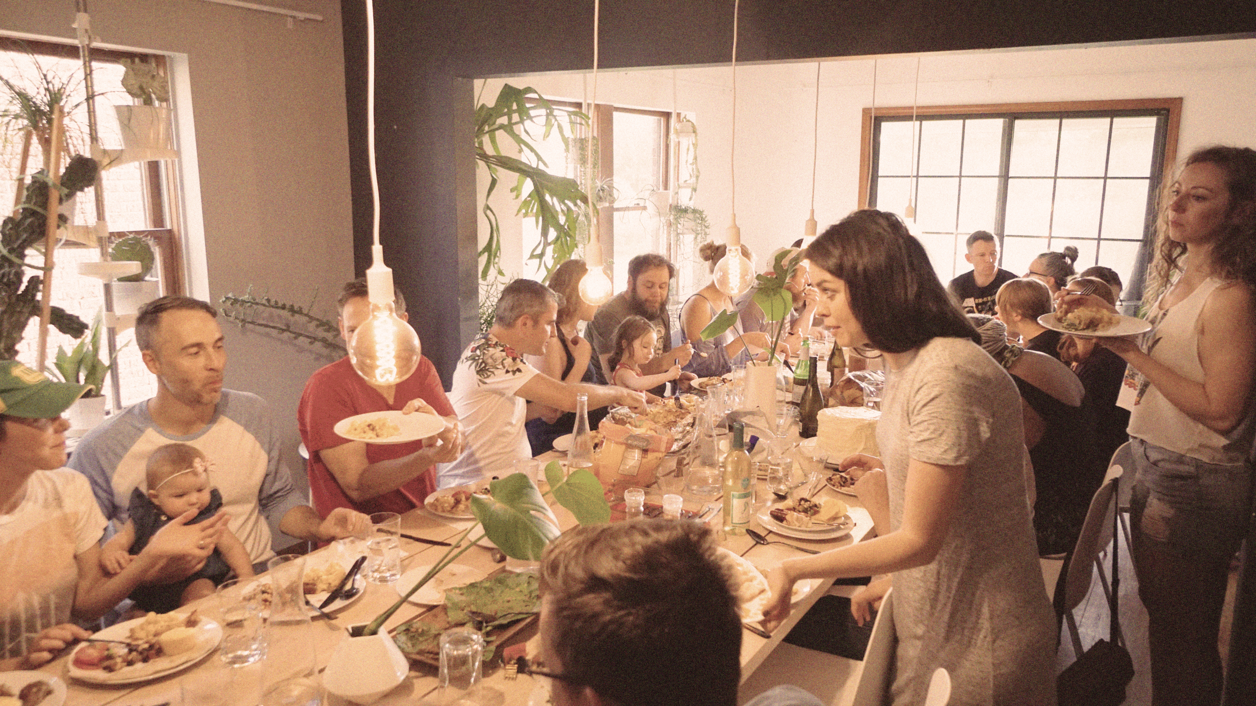 Warm, welcoming dinner party atmosphere with guests connecting over shared dishes and stories.
